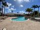A community pool with tiled deck, clear blue water, a small water feature, palm trees and lounge chairs at 4239 Corso Venetia Blvd, Venice, FL 34293