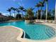 Community pool with tiled deck, clear blue water, a small water feature and palm trees at 4239 Corso Venetia Blvd, Venice, FL 34293