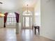 Bright foyer with tile flooring, a transom window above the door, and decorative chandeliers at 4239 Corso Venetia Blvd, Venice, FL 34293