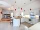 Bright kitchen features white cabinetry, an island bar, and access to the adjacent living space with fireplace at 4239 Corso Venetia Blvd, Venice, FL 34293