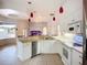 Well-lit kitchen featuring white cabinets, a breakfast bar, and stainless steel appliances at 4239 Corso Venetia Blvd, Venice, FL 34293