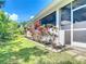 A white home exterior is surrounded by lush landscaping with garden and rear lanai, on a sunny day at 4239 Corso Venetia Blvd, Venice, FL 34293