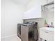 Well-equipped laundry room featuring stainless steel washer and dryer, sink, and storage cabinets at 4239 Corso Venetia Blvd, Venice, FL 34293
