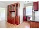 Office space featuring laminate flooring and large built-in cabinets with glass doors at 4239 Corso Venetia Blvd, Venice, FL 34293