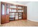 Office space featuring laminate flooring and large built-in cabinets with glass doors at 4239 Corso Venetia Blvd, Venice, FL 34293