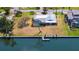A sunny aerial view of a waterfront home featuring a metal roof, screened-in lanai, and a private boat dock at 4361 Pompano Ln, Palmetto, FL 34221