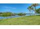 Lush green lawn leads to canal with boat docks, providing picturesque waterfront access and serene scenery at 4361 Pompano Ln, Palmetto, FL 34221