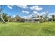 Spacious backyard showcasing lush green lawn, screened-in lanai, and white picket fence for outdoor enjoyment at 4361 Pompano Ln, Palmetto, FL 34221