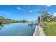 Scenic canal view with a private dock featuring boat lift; clear blue skies and lush greenery along the waterfront at 4361 Pompano Ln, Palmetto, FL 34221