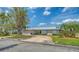 Home featuring a metal roof, circular driveway, and lush landscaping at 4361 Pompano Ln, Palmetto, FL 34221