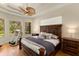 Spacious bedroom with a ceiling fan, hardwood floors, and backyard views from multiple windows at 4584 Tuscana Dr, Sarasota, FL 34241