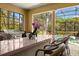 Outdoor kitchen includes a grill and bar seating overlooking the screened-in pool area at 4584 Tuscana Dr, Sarasota, FL 34241