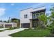 Charming modern home with a well-kept lawn, featuring a stylish dark garage door and complementary landscaping at 4726 Rivetta Ct, Sarasota, FL 34231