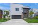 Beautiful modern home with a stylish dark garage door and a well-manicured lawn at 4726 Rivetta Ct, Sarasota, FL 34231