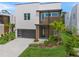 Modern two-story home boasting a sleek design, dark garage door, and beautifully landscaped front yard at 4726 Rivetta Ct, Sarasota, FL 34231
