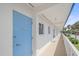 Exterior view of a condo with white siding, light blue door, and palm trees at 475 Benjamin Franklin Dr # 211, Sarasota, FL 34236
