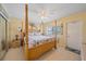 Comfortable main bedroom with a four-poster bed, light-toned walls, and bright natural light at 475 Benjamin Franklin Dr # 211, Sarasota, FL 34236