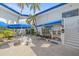 Exterior view of the office featuring a blue awning, palm trees, and an outdoor seating area at 475 Benjamin Franklin Dr # 211, Sarasota, FL 34236