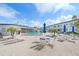 Pool surrounded by patio furniture and landscaping on a sunny day at 475 Benjamin Franklin Dr # 211, Sarasota, FL 34236