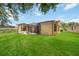 An attractive backyard with a green lawn, screened patio, and views of the surrounding landscape at 5091 Creekside Trl, Sarasota, FL 34243
