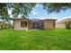 Expansive backyard featuring a manicured lawn, screened patio, and scenic views of the lush surroundings at 5091 Creekside Trl, Sarasota, FL 34243