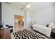 Bedroom with view to kitchen featuring a black and white patterned rug, and a black accent chair at 5091 Creekside Trl, Sarasota, FL 34243