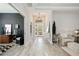 Bright and airy foyer with light wood floors, a modern chandelier, and stylish decor at 5091 Creekside Trl, Sarasota, FL 34243