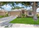 Charming single-story home featuring a manicured lawn, mature tree, and a welcoming two-car garage at 5091 Creekside Trl, Sarasota, FL 34243