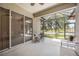This screened lanai features a ceiling fan and seating to enjoy the serene lake view and outdoor breeze at 5091 Creekside Trl, Sarasota, FL 34243
