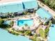 Aerial view of a community pool surrounded by lush landscaping and palm trees, complete with lounge chairs at 5669 Midnight Pass Rd # 308, Sarasota, FL 34242