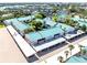 Aerial view showcasing the condo complex, covered parking, mature trees, and well-maintained landscaping at 5669 Midnight Pass Rd # 308, Sarasota, FL 34242