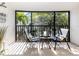 Inviting outdoor balcony with chairs, a table, and tropical landscaping views at 5669 Midnight Pass Rd # 308, Sarasota, FL 34242
