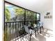 Relaxing screened balcony featuring seating area and tropical landscaping at 5669 Midnight Pass Rd # 308, Sarasota, FL 34242