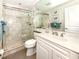 Bathroom featuring walk-in shower with glass door, white cabinets, and tiled walls at 5669 Midnight Pass Rd # 308, Sarasota, FL 34242