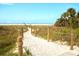 Picturesque beach path lined with wooden posts and lush greenery leading to Siesta Key Beach at 5669 Midnight Pass Rd # 308, Sarasota, FL 34242