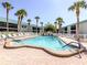 A community pool offers a refreshing retreat, surrounded by palm trees and comfortable lounge chairs at 5669 Midnight Pass Rd # 308, Sarasota, FL 34242