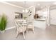 Charming dining area with a glass-top table and four chairs, adjacent to the kitchen at 5669 Midnight Pass Rd # 308, Sarasota, FL 34242