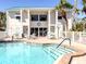 Inviting community pool with lounge chairs, a clubhouse, and tropical landscaping at 5669 Midnight Pass Rd # 308, Sarasota, FL 34242