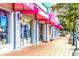 Charming storefronts with colorful awnings, unique shops, and brick sidewalks in Siesta Key Village at 5669 Midnight Pass Rd # 308, Sarasota, FL 34242