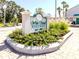 Attractive community sign for White Sands Village surrounded by lush, tropical landscaping at 5669 Midnight Pass Rd # 308, Sarasota, FL 34242
