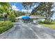 Welcoming community building with covered entry, lush greenery, and a well-maintained parking area at 5804 Garden Lakes Fern, Bradenton, FL 34203