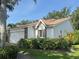 Beautiful house with an attached garage, manicured bushes, and a terracotta tile roof at 5804 Garden Lakes Fern, Bradenton, FL 34203