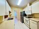 Functional kitchen with white cabinetry, tile floors, and stainless steel appliances at 5804 Garden Lakes Fern, Bradenton, FL 34203