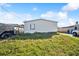 Exterior shot of home, featuring vinyl siding and an adjacent yard at 5829 Coventry Dr, Tampa, FL 33615
