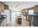 Open kitchen featuring tile floors, wooden cabinets, an island and white appliances at 5829 Coventry Dr, Tampa, FL 33615