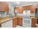 Efficient kitchen features wood cabinets, white appliances, and a view of the backyard at 602 Park Cir, Bradenton, FL 34207