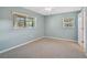 Bright bedroom with carpeting, light blue walls, and two windows for ample natural light at 602 Park Cir, Bradenton, FL 34207