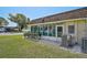 Rear exterior view of the home with a large enclosed patio and well-maintained lawn at 602 Park Cir, Bradenton, FL 34207