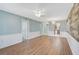 Spacious living room with hardwood flooring, light blue walls, and stylish white wainscoting at 602 Park Cir, Bradenton, FL 34207