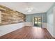 Bright living room with a rustic wood accent wall and sliding glass doors to the patio at 602 Park Cir, Bradenton, FL 34207